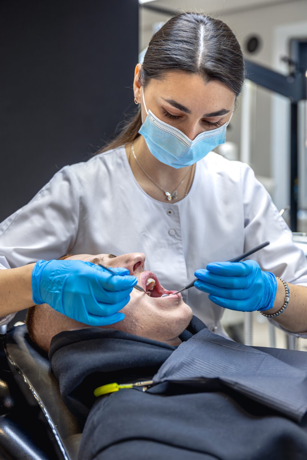 female dentist treats patients teeth stomatologist working with professional equipment